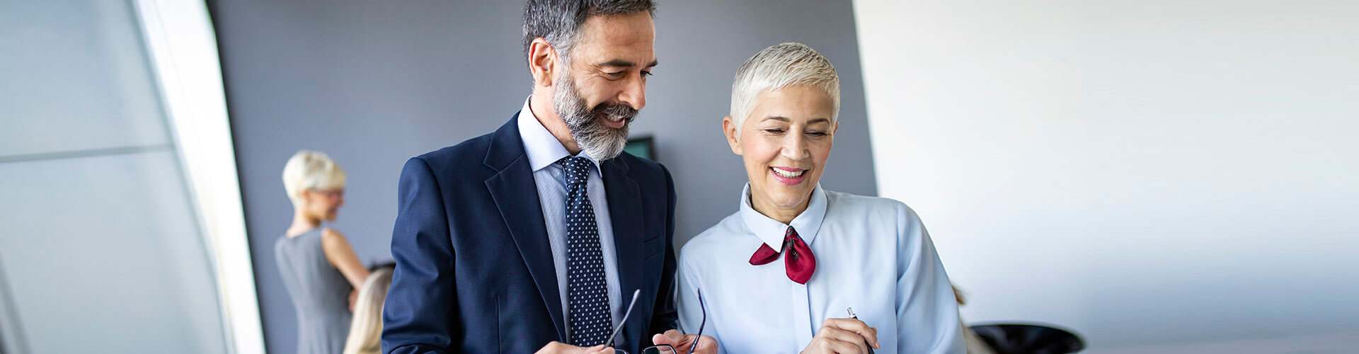 Depósitos Empresas - Hombre y mujer de negocios en una sala de reuniones sonriendo y hablando de negocios Depósitos Empresas - Hombre y mujer de negocios en una sala de reuniones sonriendo y hablando de negocios