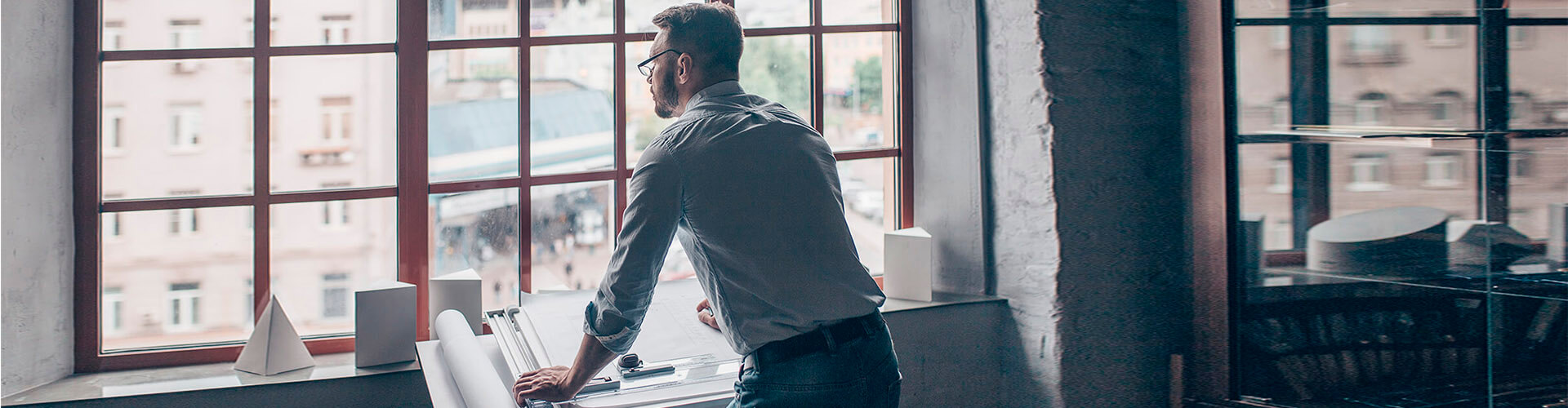 Anticipo de Exportaciones para empresas - Un hombre de negocios mirando por la ventana Anticipo de Exportaciones para empresas - Un hombre de negocios mirando por la ventana