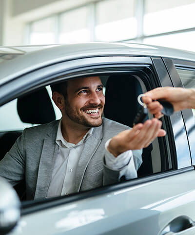 Modulo texto Comprar un coche - Chico joven en su coche sentado mientras le dan las llaves de su coche nuevo Modulo texto Comprar un coche - Chico joven en su coche sentado mientras le dan las llaves de su coche nuevo