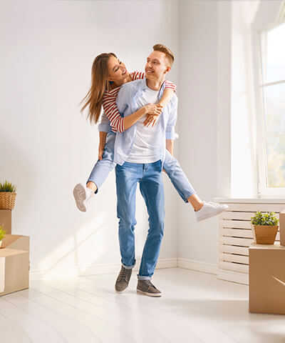 Comprar vivienda - Pareja joven mudandose a su nueva casa o vivienda sonriendo y felices