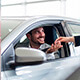 Momento Comprar un coche - Chico joven en su coche sentado mientras le dan las llaves de su coche nuevo Momento Comprar un coche - Chico joven en su coche sentado mientras le dan las llaves de su coche nuevo