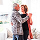 Momento mi jubilacion - Pareja senior sonriendo y bailando en el salon de su casa Momento mi jubilacion - Pareja senior sonriendo y bailando en el salon de su casa