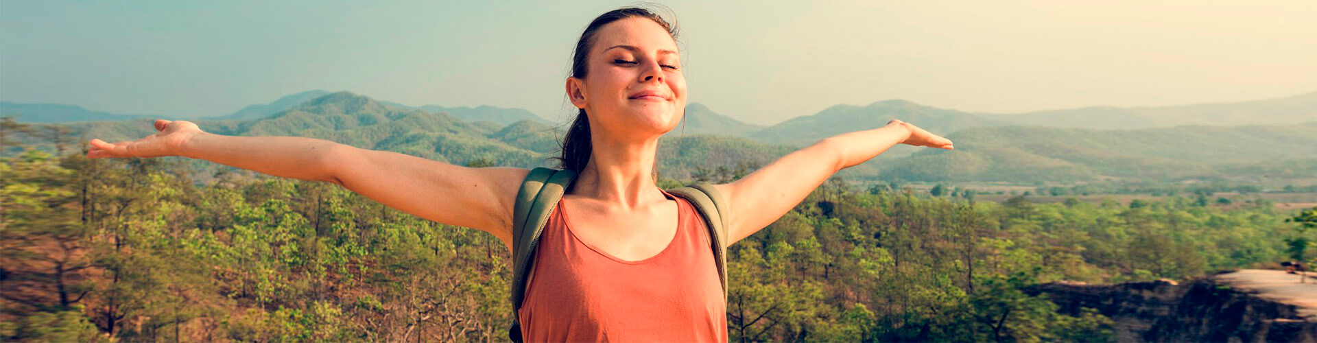 Préstamo Personal - Una chica joven con los brazos abiertos sonriendo en el monte Préstamo Personal - Una chica joven con los brazos abiertos sonriendo en el monte