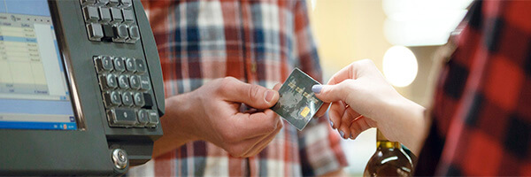 TPV Fijo - Hombre dando una tarjeta de credito a una cajera en un supermercado junto a un tpv TPV Fijo - Hombre dando una tarjeta de credito a una cajera en un supermercado junto a un tpv