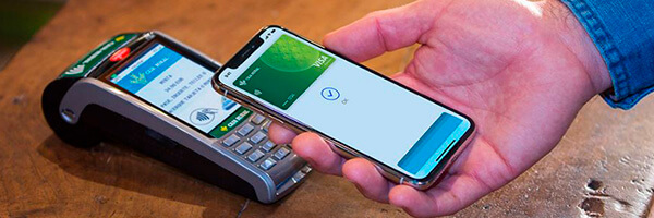 Apple Pay - Persona pagando con apple pay en su movil en el tpv de un comercio