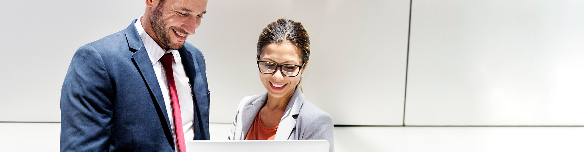 Financiacion de Impuestos y Seguros Sociales - Hombre y mujer de negocios con traje y corbata mirando una tablet y hablando de negocios y financiacion de empresas Financiacion de Impuestos y Seguros Sociales - Hombre y mujer de negocios con traje y corbata mirando una tablet y hablando de negocios y financiacion de empresas