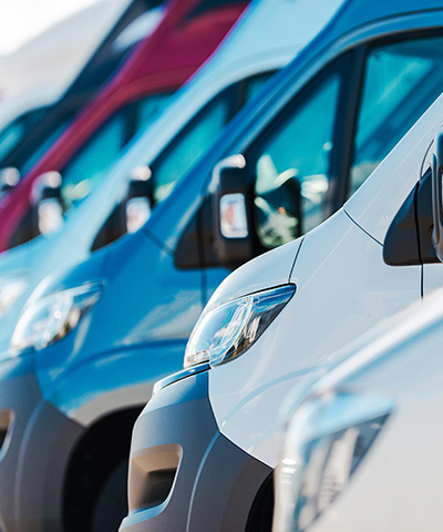 Momento Renovar flota de vehiculos - Flota de furgonetas de empresa de diferentes colores aparcadas unas junto a otras Momento Renovar flota de vehiculos - Flota de furgonetas de empresa de diferentes colores aparcadas unas junto a otras