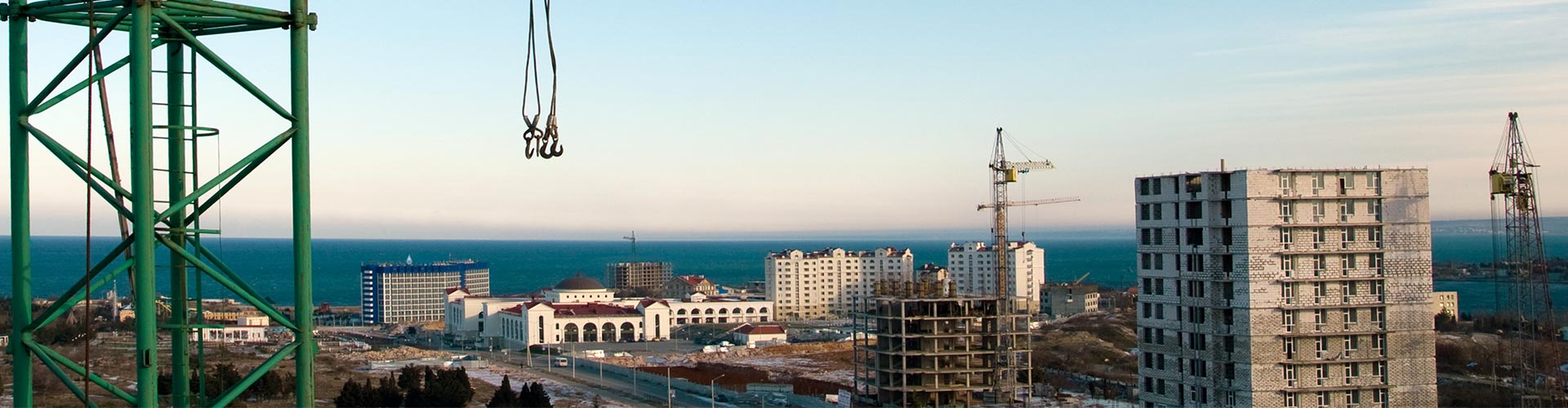 Seguro Decenal de Daños - Obra construyendo edificios con gruas, camiones y trabajadores trabajando Seguro Decenal de Daños - Obra construyendo edificios con gruas, camiones y trabajadores trabajando
