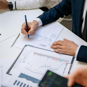 Mesa de trabajo con papeles y personas escribiendo