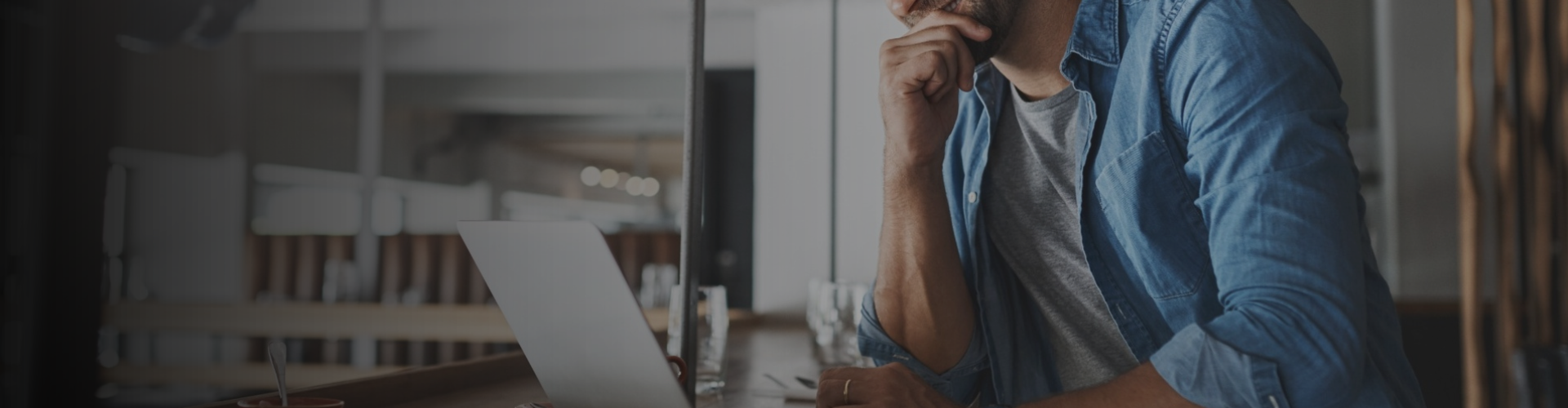 Hombre con camisa vaquera delante del ordenador