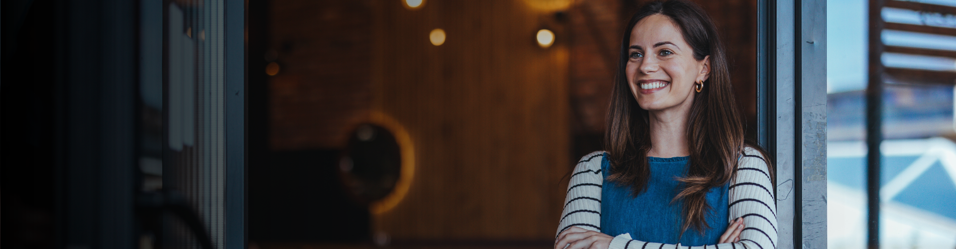 Mujer sonriendo en la puerta de su tienda