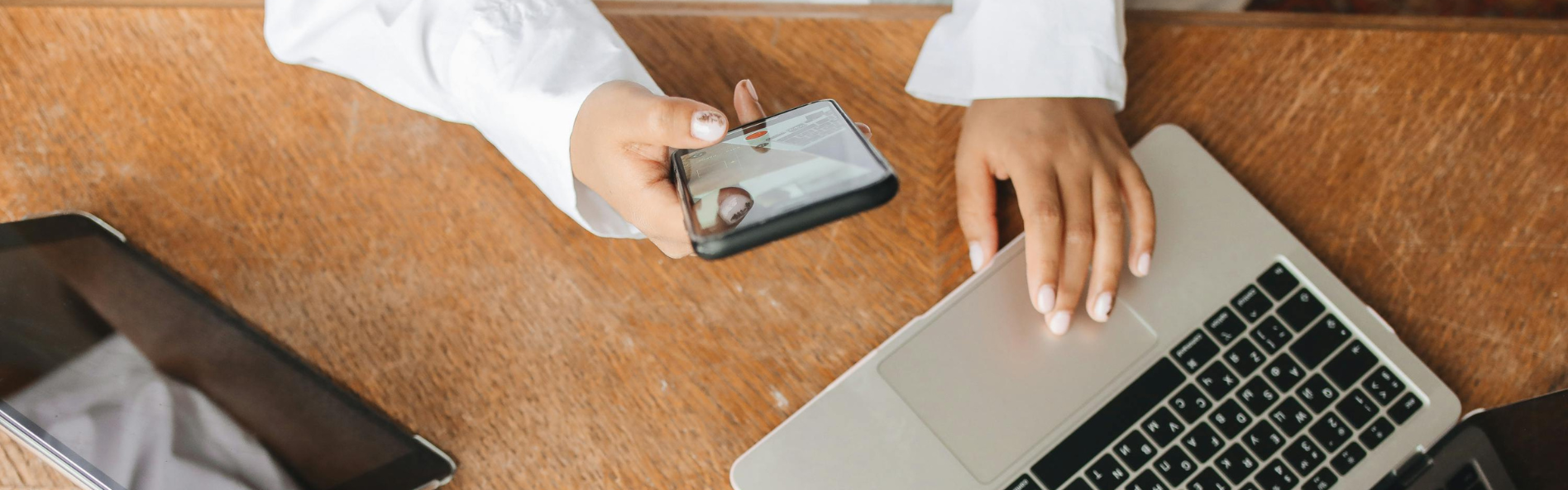 manos de mujer con su ordenador y movil