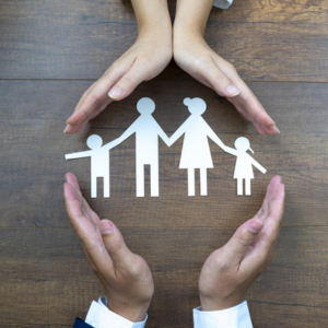 Manos de hombre y niño sobre un recorte en papel de una familia