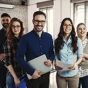 Programa Porque somos así - Grupo de personas en fila sonriendo unas al lado de otras en la oficina