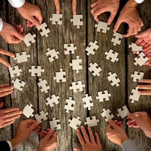 Búsqueda de sinergias - Diferentes manos haciendo un puzzle con piezas Búsqueda de sinergias - Diferentes manos haciendo un puzzle con piezas