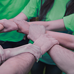 Fondo de solidaridad - Personas agarradas de la mano con camiseta verde Fondo de solidaridad - Personas agarradas de la mano con camiseta verde