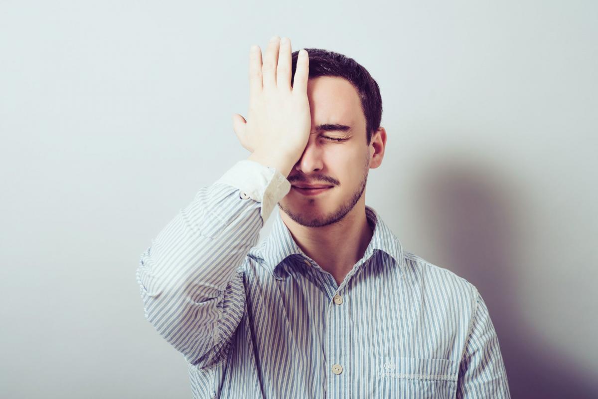 Hombre con la palma de la mano en la cara Hombre con la palma de la mano en la cara