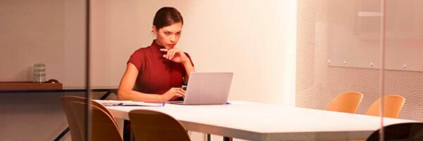 Gestión de recibos - Una mujer trabajando con un portátil en una sala de la oficina