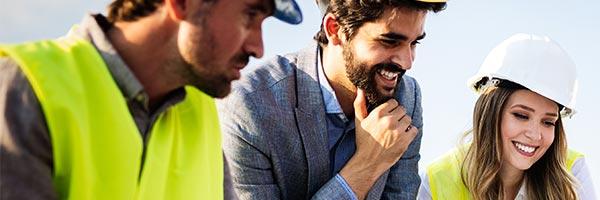 Seguro de Todo Riesgo Construccion - Grupo de arquitectos y trabajadores de construccion trabajando juntos frente a un plano de un edificio Seguro de Todo Riesgo Construccion - Grupo de arquitectos y trabajadores de construccion trabajando juntos frente a un plano de un edificio