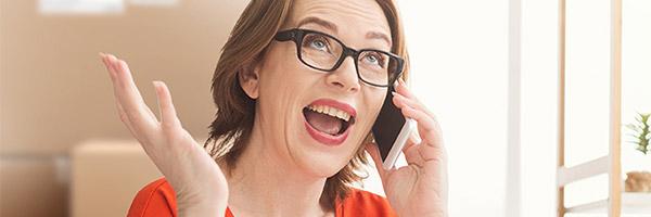 Programa Porque Somos Así Autónomos - Mujer de mediana edad autónomos gafas y camisa roja hablando por teléfono móvil desde su negocio Programa Porque Somos Así Autónomos - Mujer de mediana edad autónomos gafas y camisa roja hablando por teléfono móvil desde su negocio
